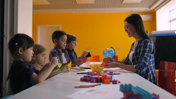 Multicultural Kids Making Ship with Colored Paper