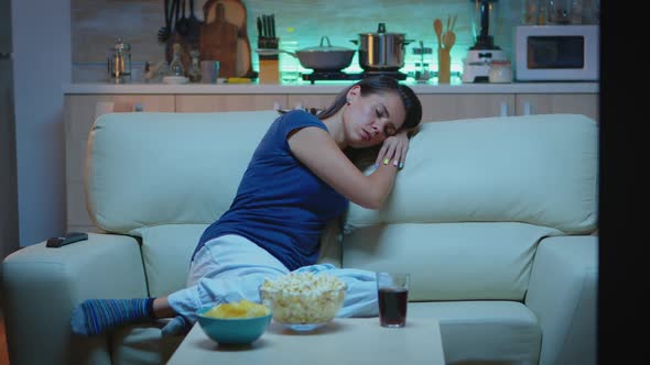 Woman Sleeping on a Sofa in Front of TV