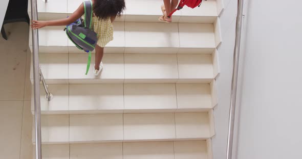 Video of top view of diverse girls walking upstairs at school