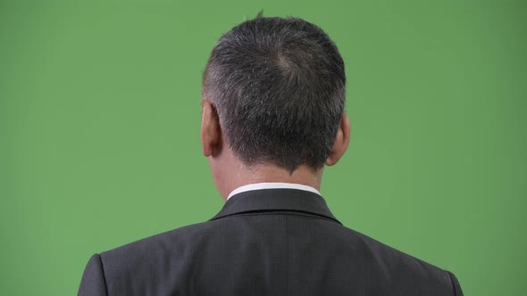 Mature Japanese Businessman Looking Over the Shoulder