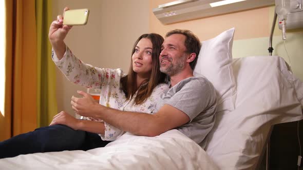 Joyful Husband and Wife Taking Selfie in Hospital