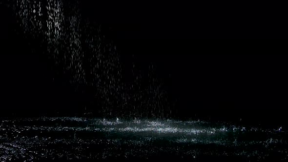 Spray Spatters Rain Fall Against on the Water Surface Which Glow. Black Background. White Neon