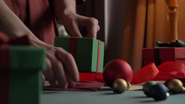 woman preparing gifts for christmas at home on the table