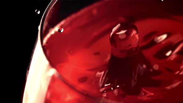 Super Slow Motion Drop of Wine with Splashes Falls Into the Glass