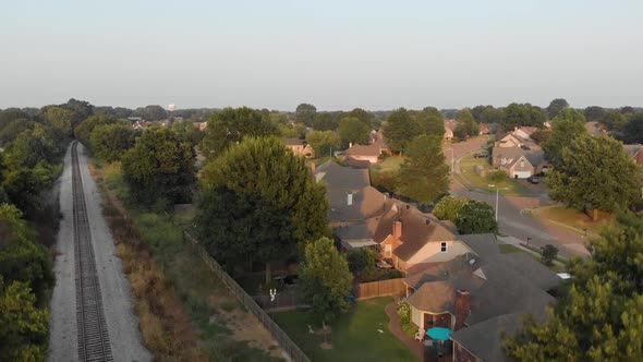 AERIAL: Suburban Landscape with Railroad revealed at Sunset