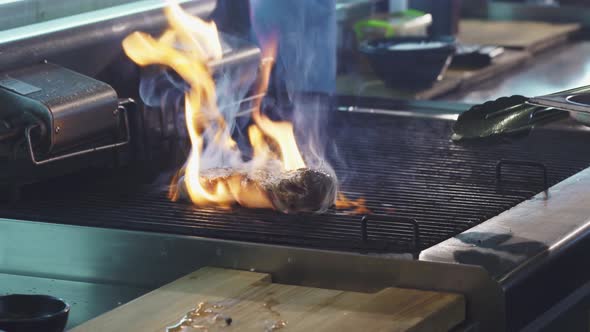 Close Up Shot of a Pork Meat on the Grill in Flames of Fire