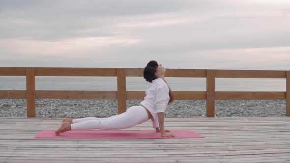 Woman Does Yoga Poses Outside in Nature.