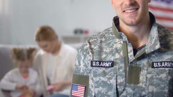 Young Mother Playing With Daughter, Looking at Military Husband, Family Defense