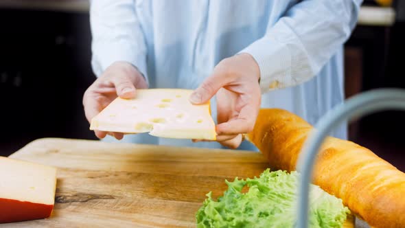 The Woman Holds in Her Hands a Piece of Cheese with Holes