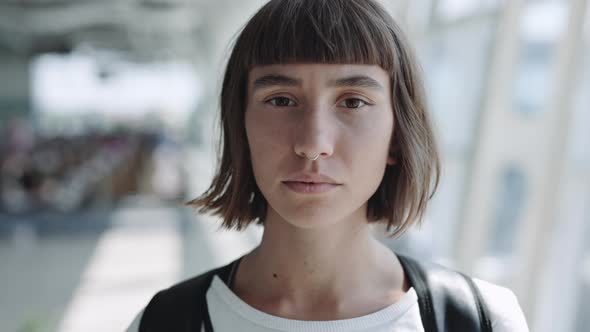 Portrait of Calm Woman with Backpack Standing at Airport