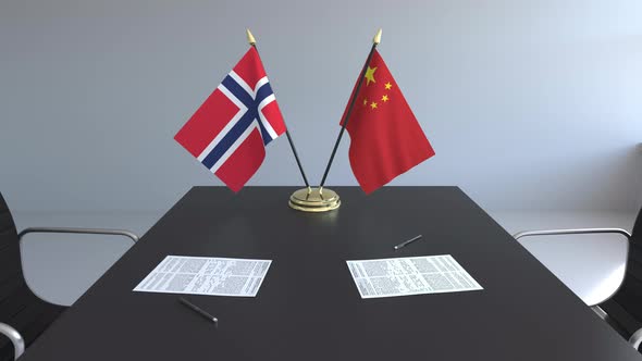 Flags of Norway and China and Papers on the Table