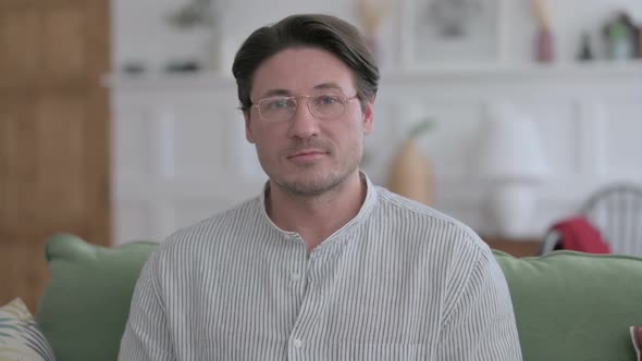 Portrait of Man Looking at Camera at Home