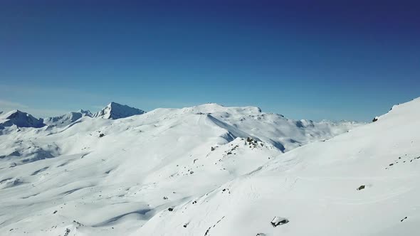 Aerial drone view of snow covered mountains in the winter