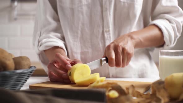 Cook, Wife, Mother. Cooking Lunch, Dinner In  Kitchen. Cutting Vegetables, Potatoes On Wooden Board