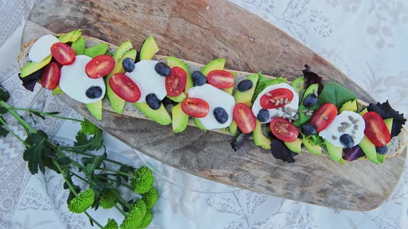 Delicious, healthy, avocado, mozzarella and tomato baguette recipe on a bread board for a perfect pi