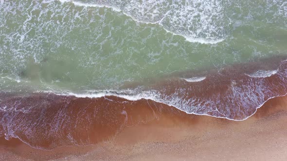 Waves View From Above. Sea Waves Over a Sandy Beach. Top View. 4K Video