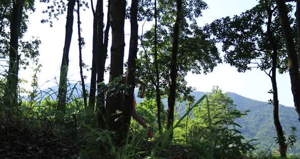 Woman trail runner running in tropical forest mountain