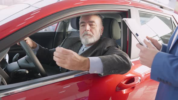 Positive Handsome Senior Caucasian Man Opening Car Keys Sitting on Driver's Seat and Smiling Looking