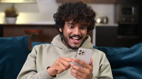 Happy Satisfied Man Holding Smartphone and Smiling Making Yes Gesture
