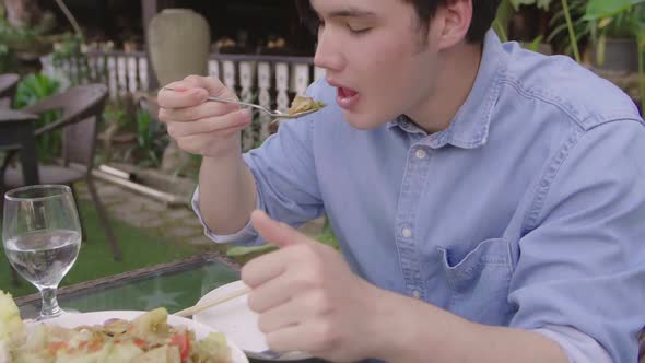 Young Man Eating Spicy Green Papaya Salad