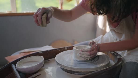 Woman is Using Potter Wheel for Modeling Cup or Bowl