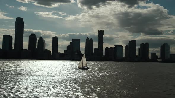 Sailboat Sails on the Background of the City Manhattan in New York at Sunset