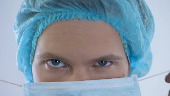 Male Physician Wearing Surgical Mask, Preparing for Patient Examination, Closeup