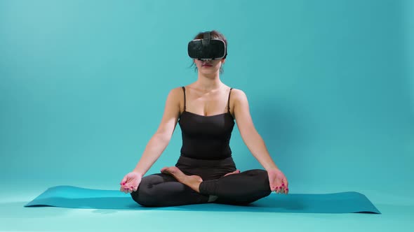 Woman Sitting in Lotus Position with Vr Glasses on Yoga Mat