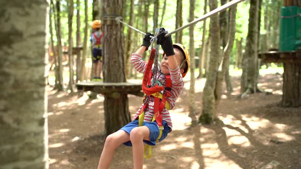 Boy Moves with the Help of His Hands on the Zip Line in the Adventure Park