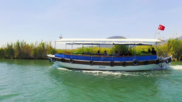 Tourist Boat with Turkish Flag Sailing on the River. Excursion on the River Dalyan, Turkey