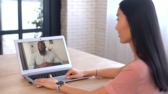 An Attractive Young Asian Woman is Using a Laptop for Video Call