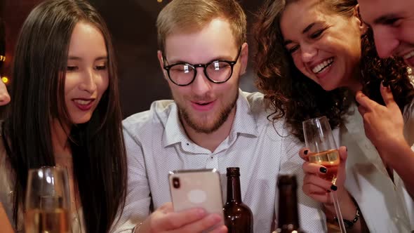 Portrait Shot of Group of Happy Hipster Students Watching Video, Photo on the Smart Phone Together