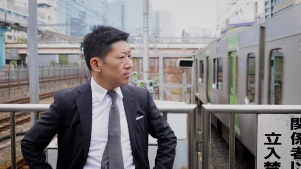 Japanese businessman waiting on a train platform
