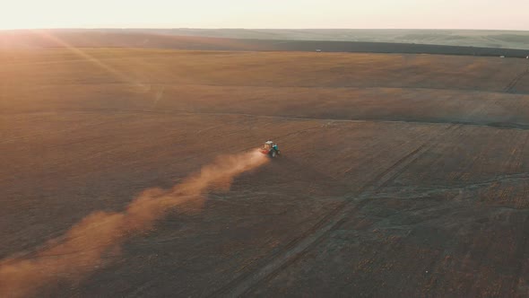 Tractor Spreading Artificial Fertilizers in Green Field