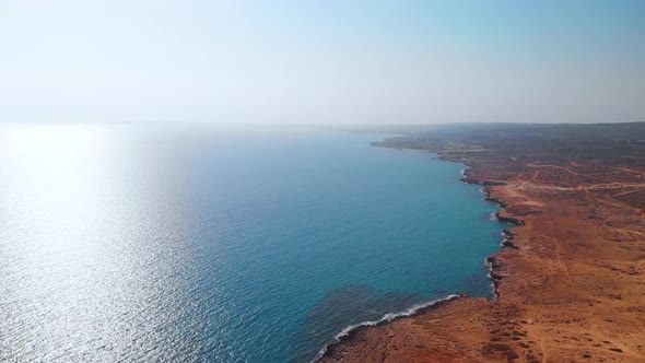 Aerial shot flying over the rocky coast of Cavo Greko in Cyprus