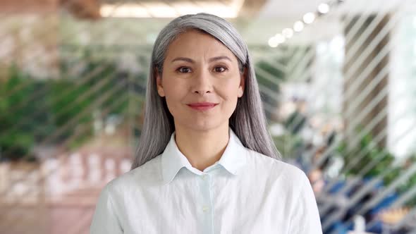 Successful Older Asian Businesswoman Standing in Modern Office