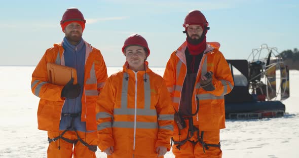 Portrait of Professional Rescue Service Team in Uniform Posing at Camera on Frozen Bay