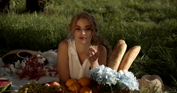 Young Beautiful Girl On A Picnic Reads A Book