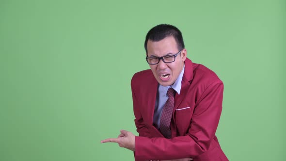 Happy Asian Businessman with Eyeglasses Pointing Finger and Laughing