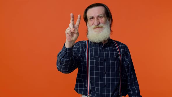 Mature Grandfather Showing Victory Sign Hoping for Success and Win Doing Peace Gesture Smiling