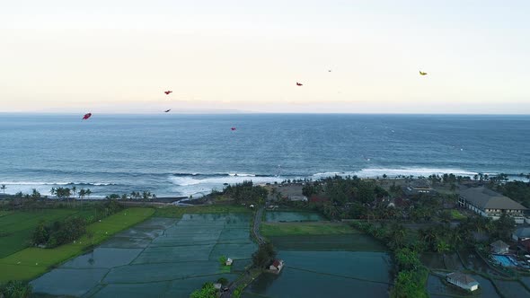 Kites Fly on the Ocean Shore Near the Rice Terraces in the Evening