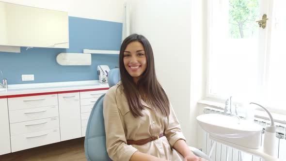 Smiling woman looking at camera while sitting in the dental chair