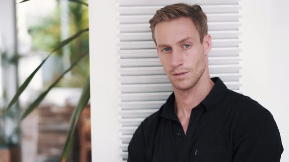 Portrait of Blue-eyed Handsome Blond Man in Black Shirt, Looking at Camera