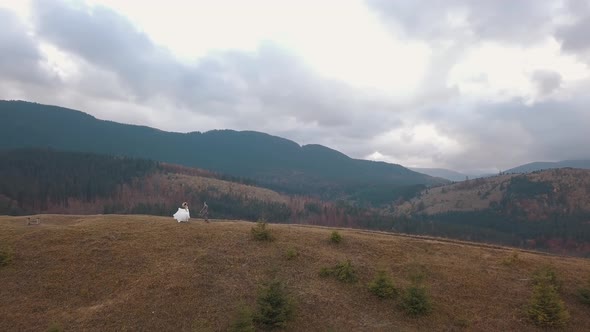 Lovely Newlyweds Bride Groom Dancing on Mountain Autumn Slope Wedding Couple Family Aerial View