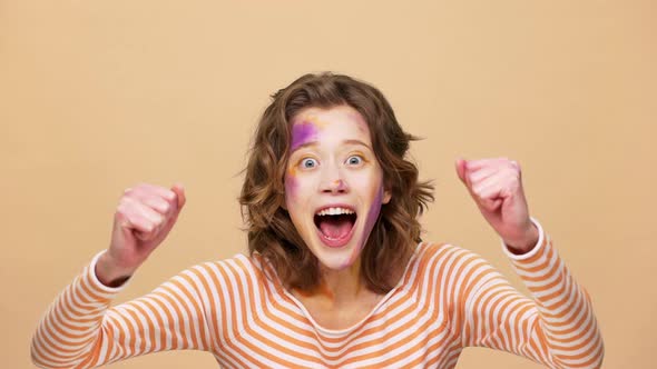 Portrait of Emotional Woman 20s with Colorful Designer Painting on Face Shouting and Clenching Fists