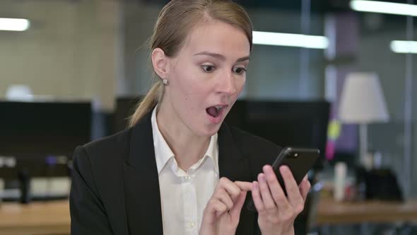 Portrait of Young Businesswoman Celebrating Success on Smartphone