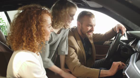 Young Caucasian Couple Sit Inside of New Car in Dealership