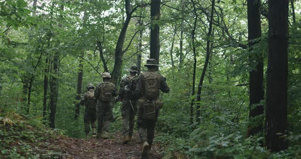 Soldiers Moving Thorugh Forest During Tactical Action Concept of War and Attacking