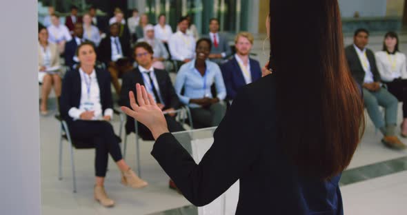 female speaker speaks in a business seminar 4k