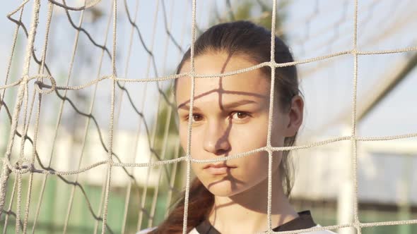 Portrait of Young Serious Woman Football Player Wearing Uniform Looking Into Camera in Soccer Gate